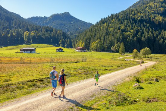 Paar mit Kind wandert zu den Röthelmoosalmen in Ruhpolding