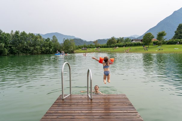 Mädchen springt zu ihrer Mutter in den Reifinger See
