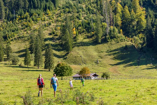 Familie wandert im Herbst zu den Röthelmoosalmen