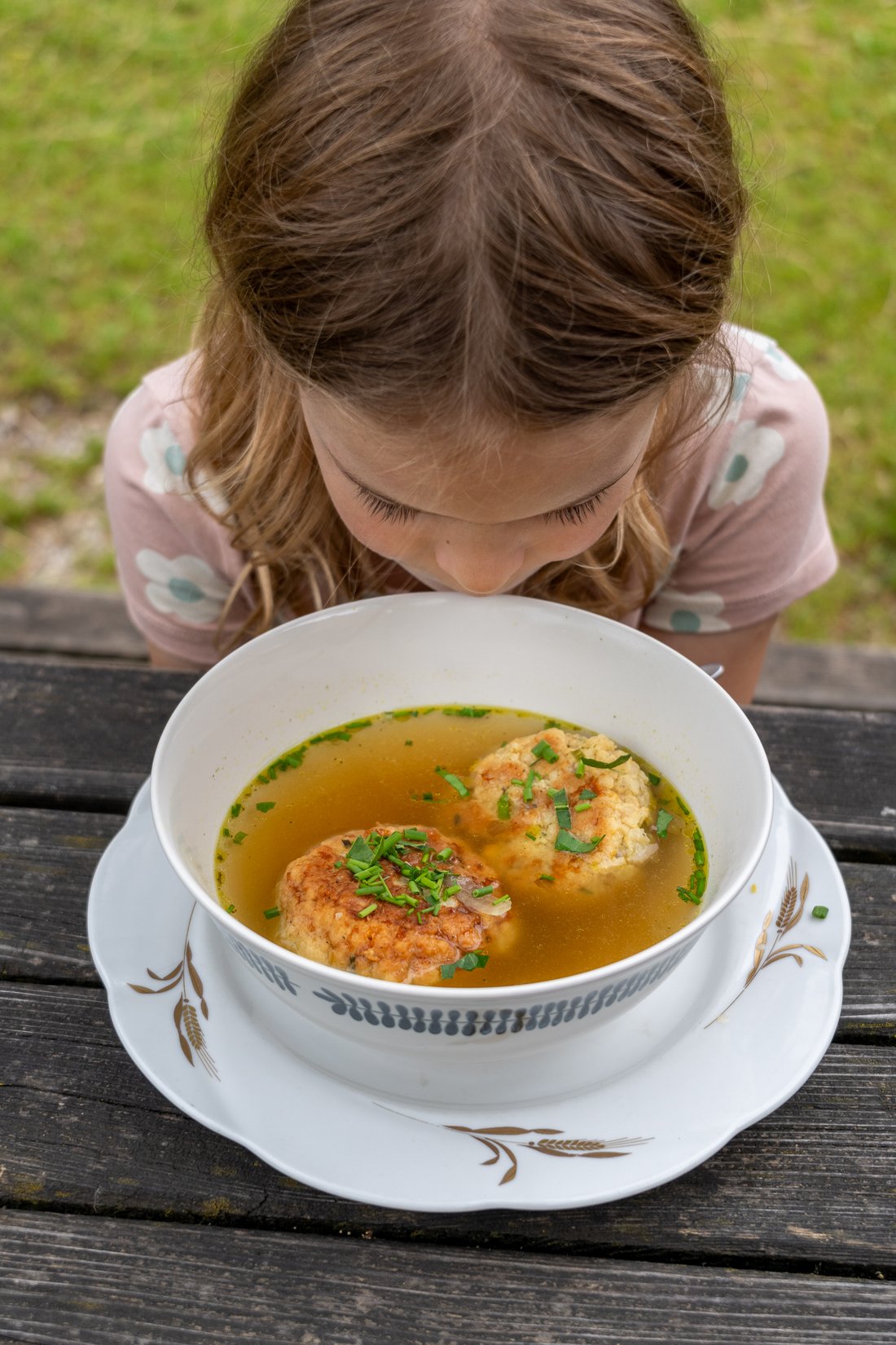 Mädchen genießt Suppe auf Alm