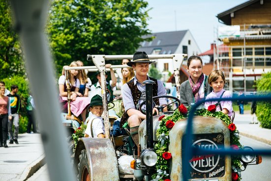 Familie auf einem Traktor bei der Pfingstroas in Inzell 