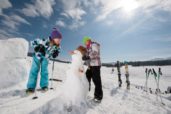 Kinder beim Schneemannbau