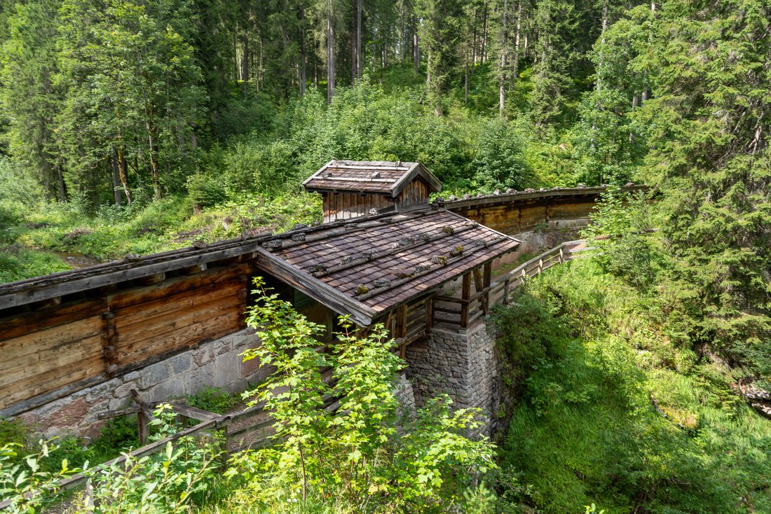 Holzmauer auf Wanderweg im Wald 